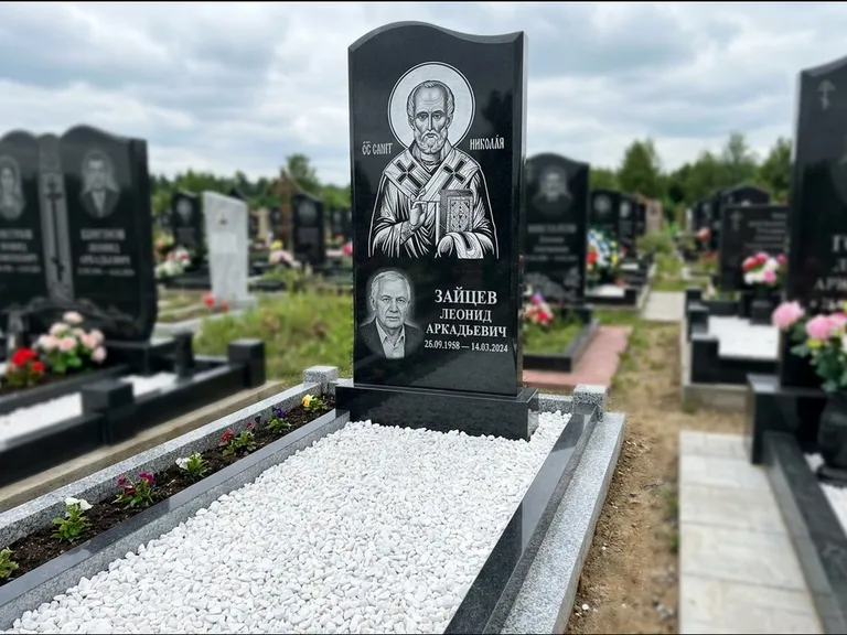 Памятник с гравировкой иконы: стела с крестообразным навершием — икона в резной рамке-киоте, газон без ограды, стриженая трава, работа «Раевская» в Ижевске