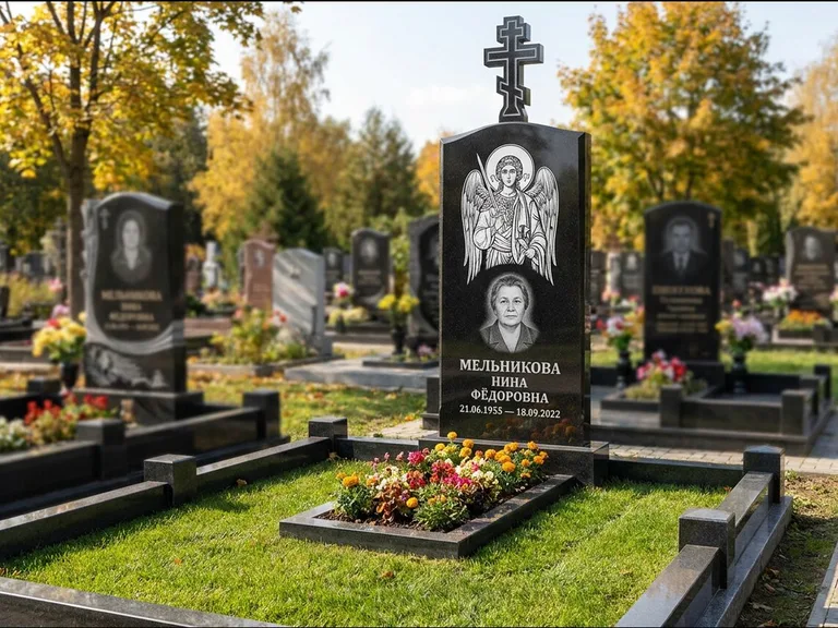 Памятник с гравировкой иконы: округлая стела-медальон с ликом — гравировка Богородицы «Семистрельная», луговые травы и полевые цветы за участком, работа «Гущин» в Ижевске