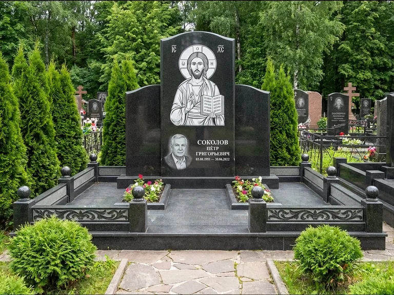 Памятник с гравировкой иконы: широкая горизонтальная лежачая плита-стела — икона в резной рамке-киоте, серая гравийная отсыпка с бордюром, работа «Богданова» в Ижевске
