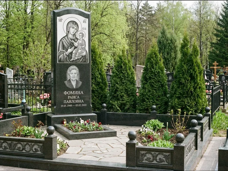 Памятник с гравировкой иконы: высокий гранёный обелиск с крестом-навершием — гравировка образа Матроны Московской, открытый участок без ограды, работа «Третьяков» в Ижевске