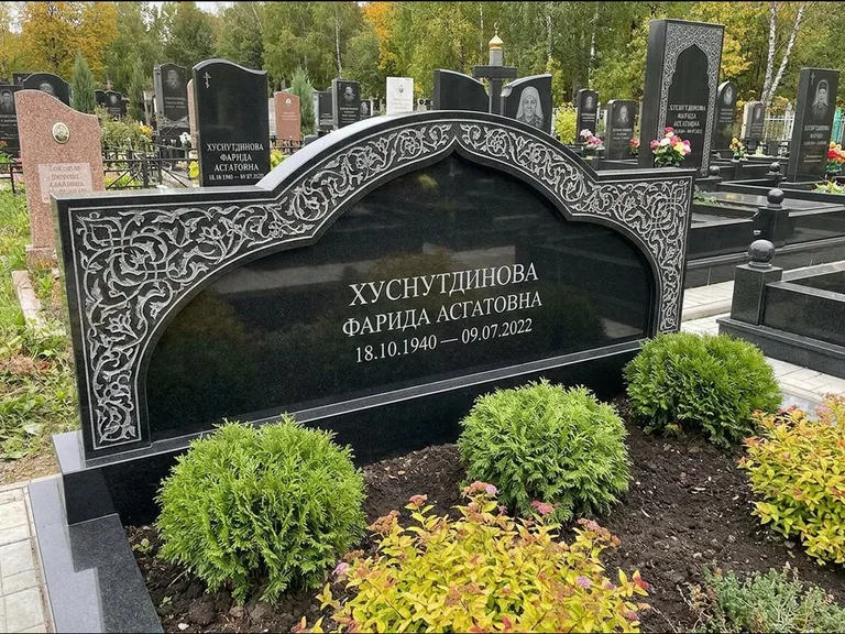 Мусульманский памятник: вытянутая горизонтальная семейная стела с аркой — белая гравировка силуэта мечети с минаретами, участок с декоративными кустами, работа «Зарипова» в Ижевске