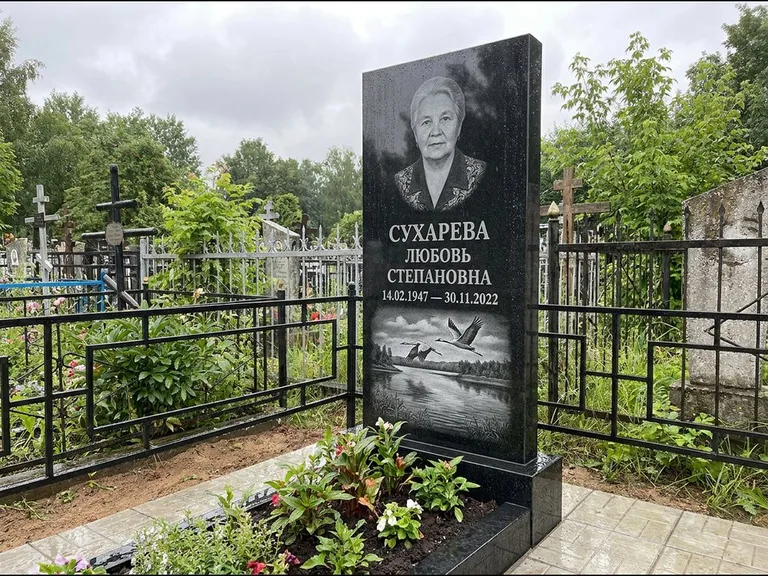Памятник с гравировкой журавлей — гравировка пары журавлей над гладью озера в нижней части, работа «Сухарева» в Ижевске